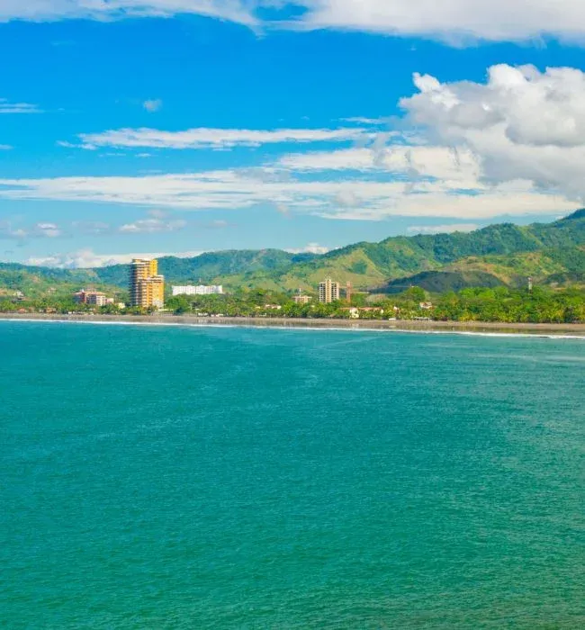 La baie de Jaco et ses immeubles au pied des collines vertes